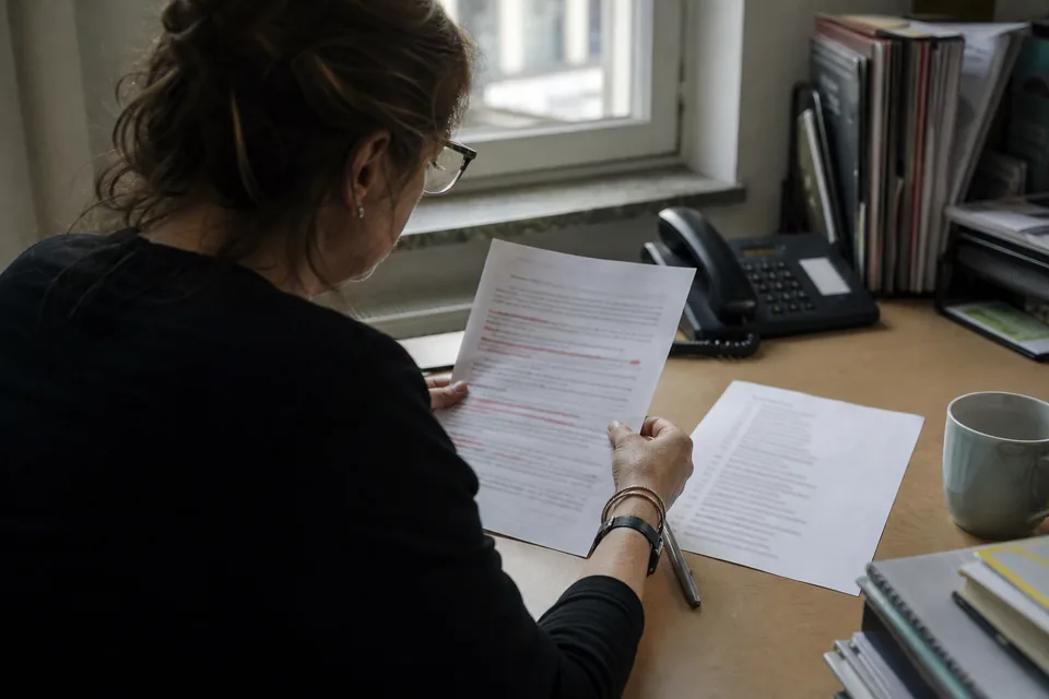 PR lead reading a printed coverage report with highlighted lines at her desk