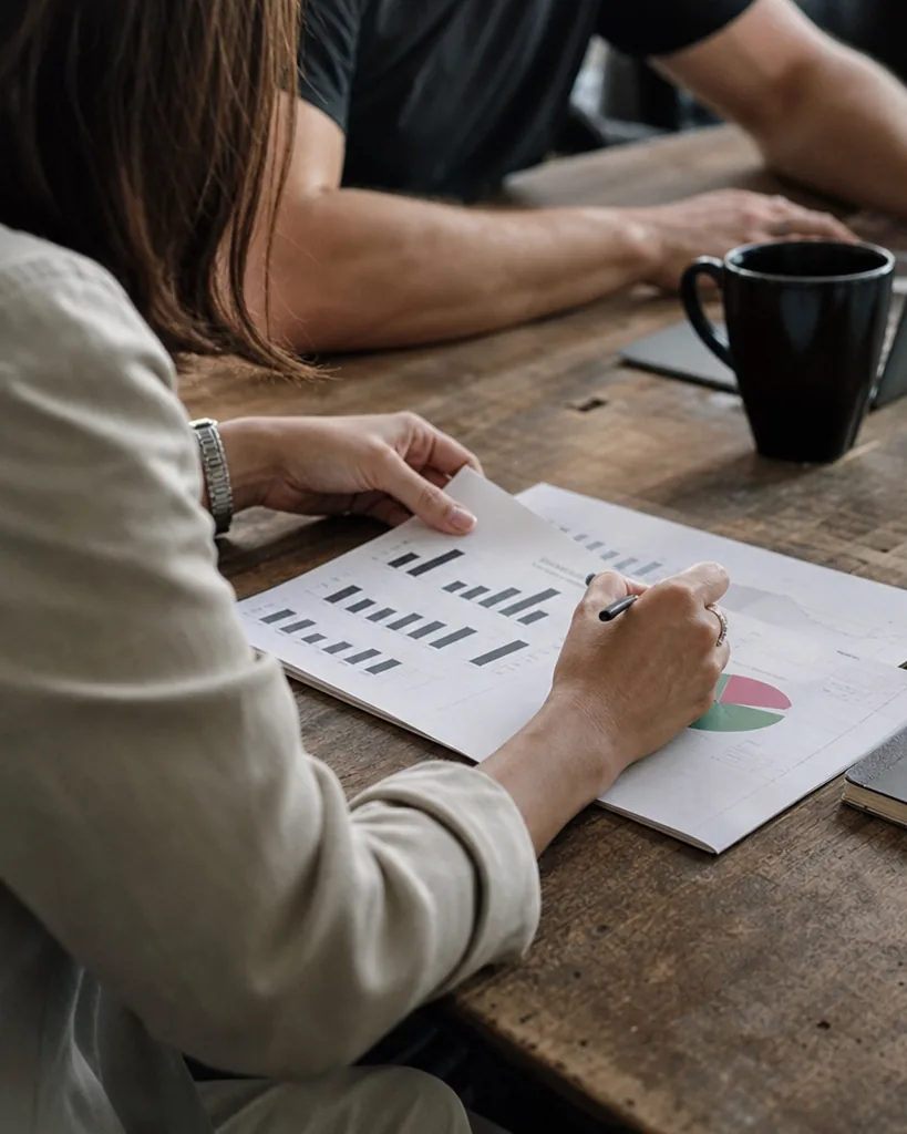 Marketing lead marking a printed weekly mention report with charts